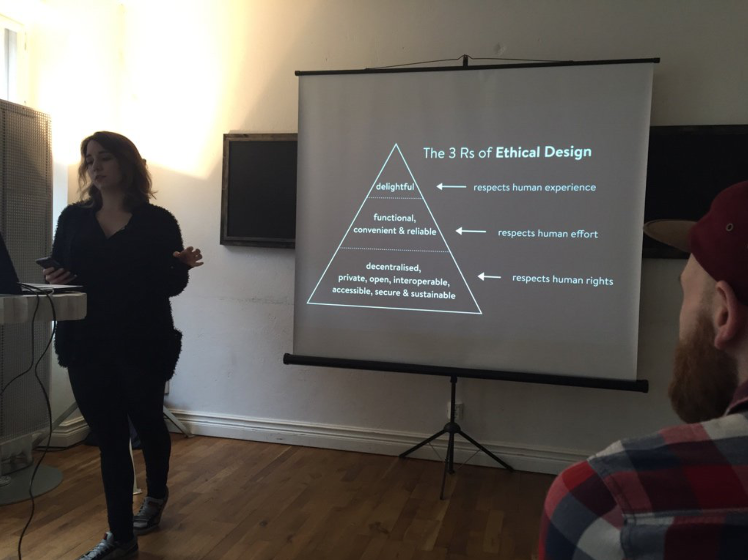 Me talking with a slide of the Ethical Design Manifesto (The 3 Rs of Ethical Design) in a fluffy black cardigan