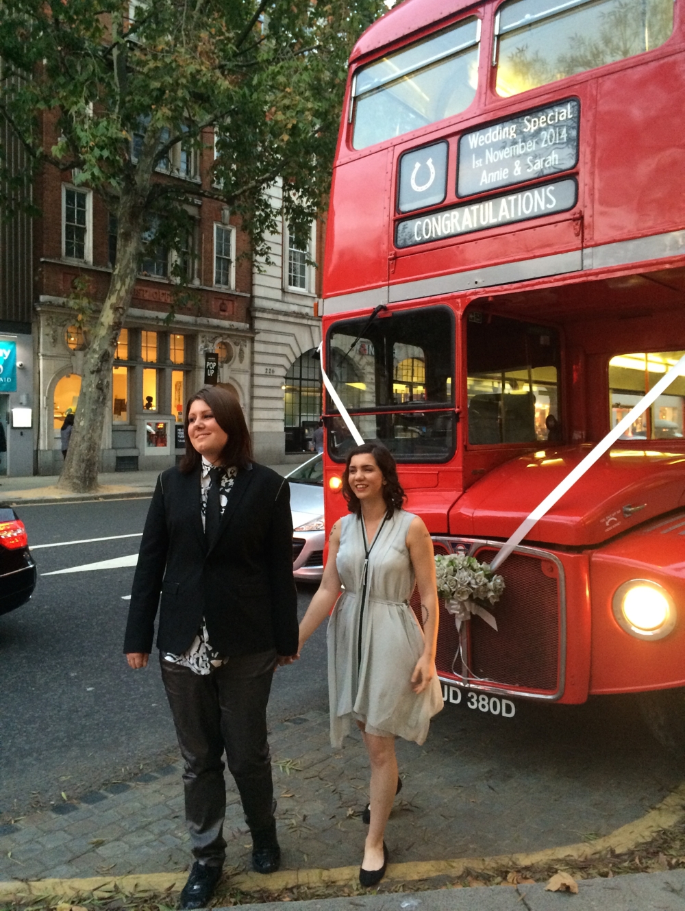 Sarah and Annie standing in front of their wedding bus