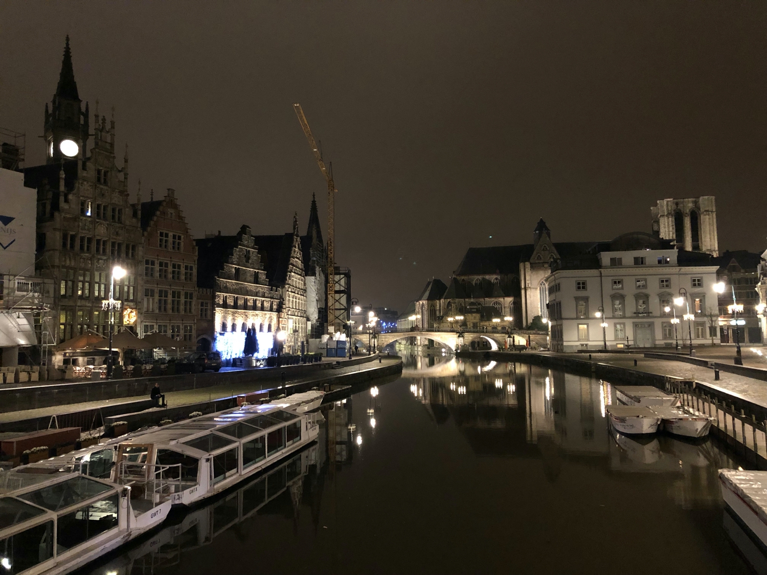 View of old buildings in Ghent over a canal at night.