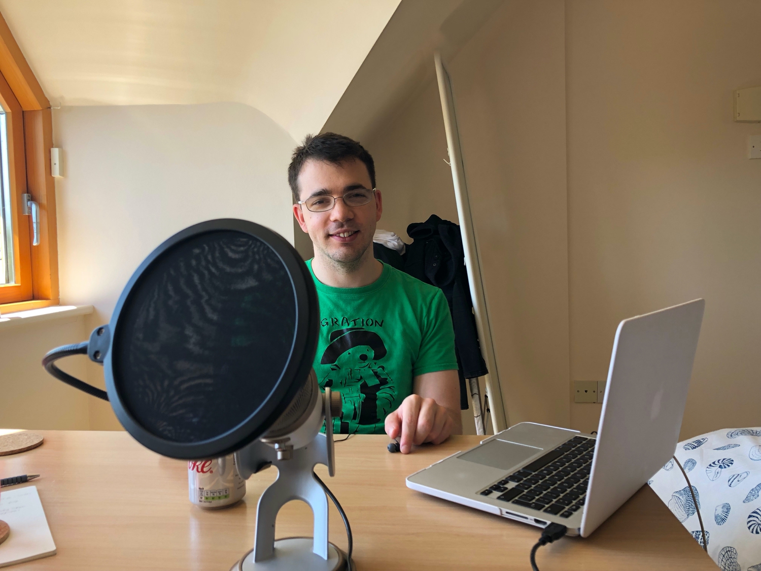 Sam sitting across the desk from me with some recording equipment.