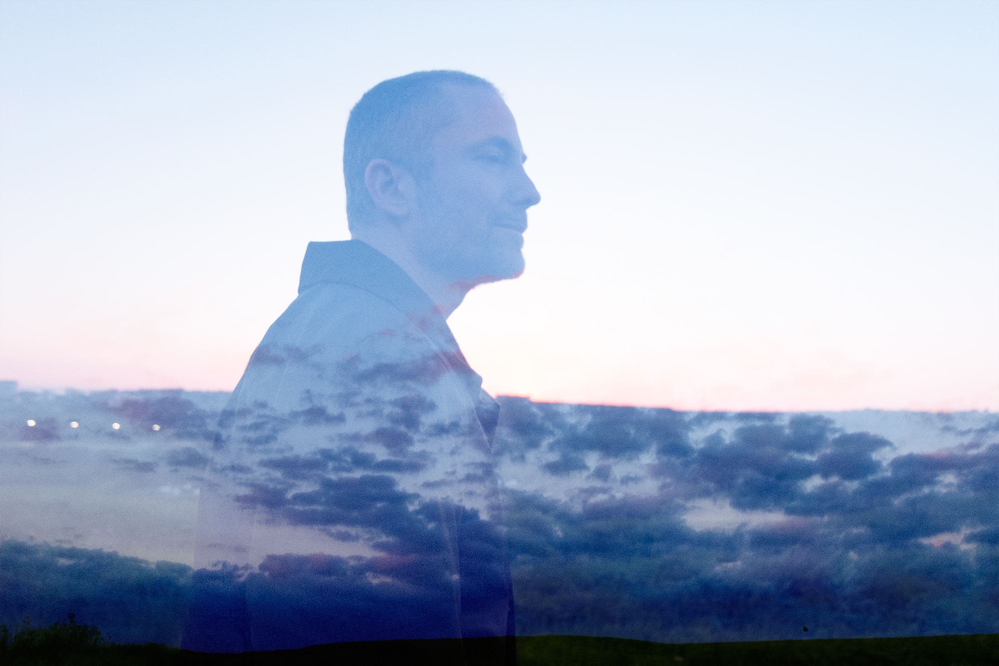 Profile of Aral, overlaid on purple and blue clouds in the sky