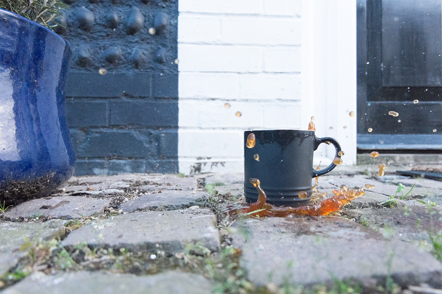 Tea splashing out of a mug, outdoors on a patio