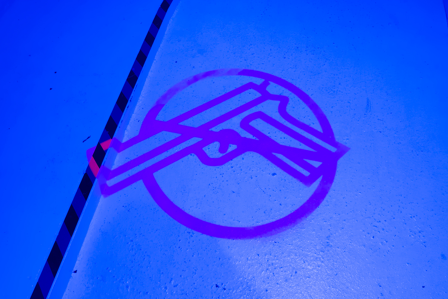 A projected luminous anti-gun symbol on a floor