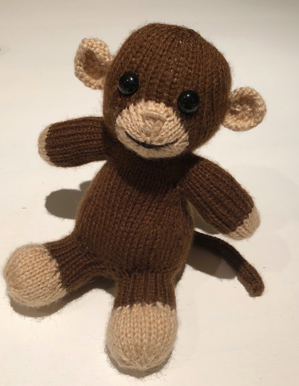 a knitted baby monkey with shiny button eyes.