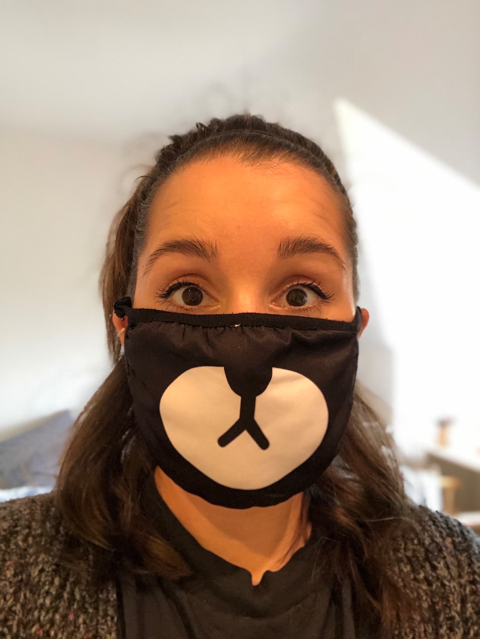 Selfie of me wearing a cloth face mask, decorated with a cartoon bear nose and mouth covering my own nose and mouth.