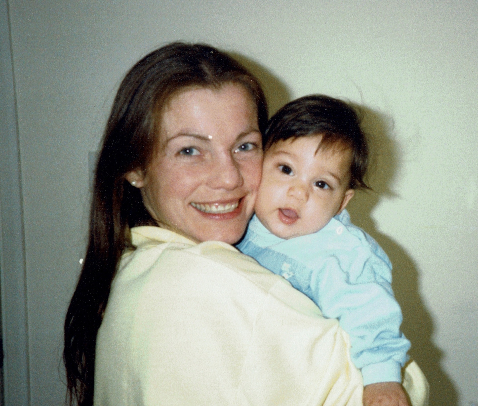 My mother aged ~27 holding a ~1 year old baby me with a massive grin on her face.