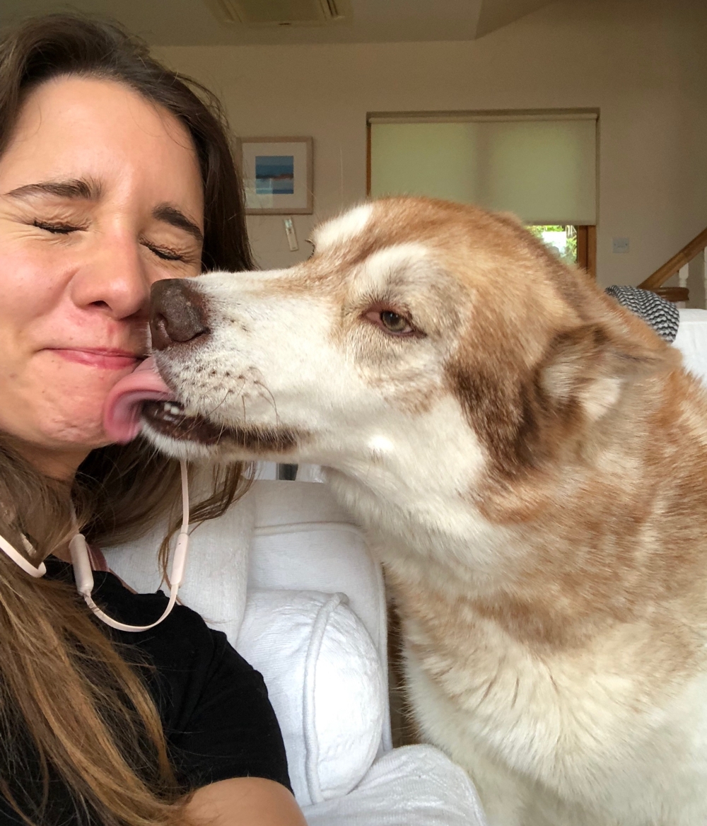 Selfie of me and Oskar the huskamute, he’s licking my face.